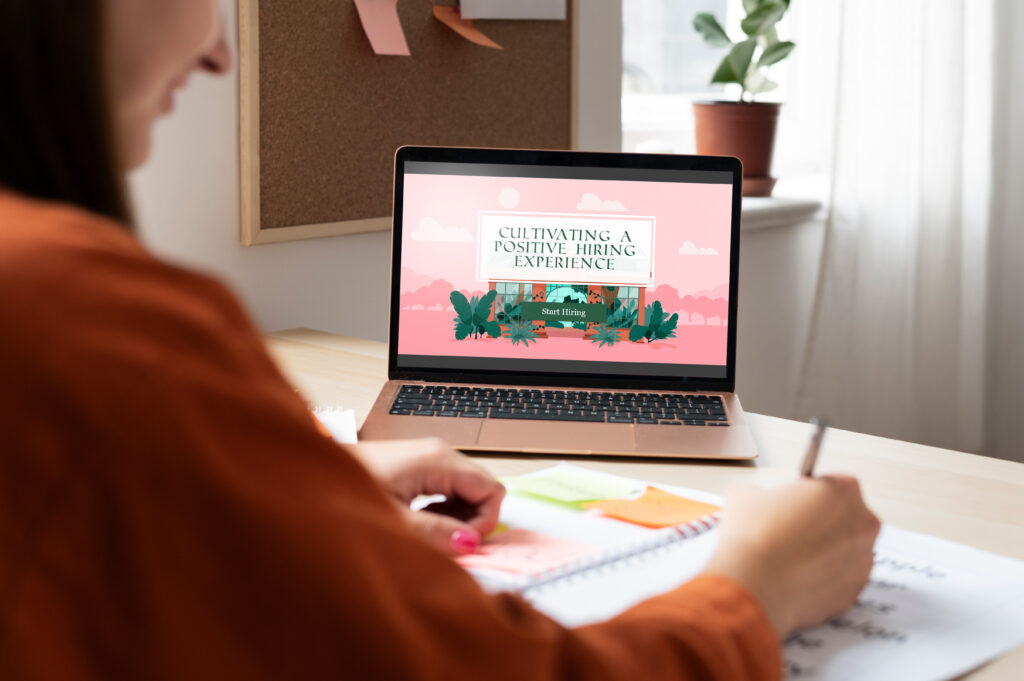 Woman sitting at laptop with E-Learning experience on screen.